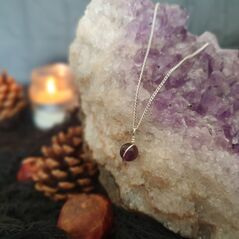 Small amethyst sphere bound in a simple wire wrap onto silver chain