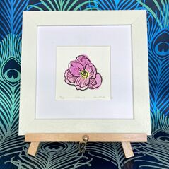 Purple Corcus framed in white on a beech easel against a peacock background