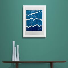 Blue White and Teal Waves Print in Framed in White on a Blue Wall Above Dark Shelf and Vase Set