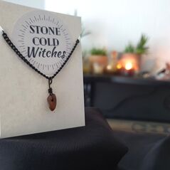 Small tigers eye polished crystal on a black chain, bound using a simple black wire wrap